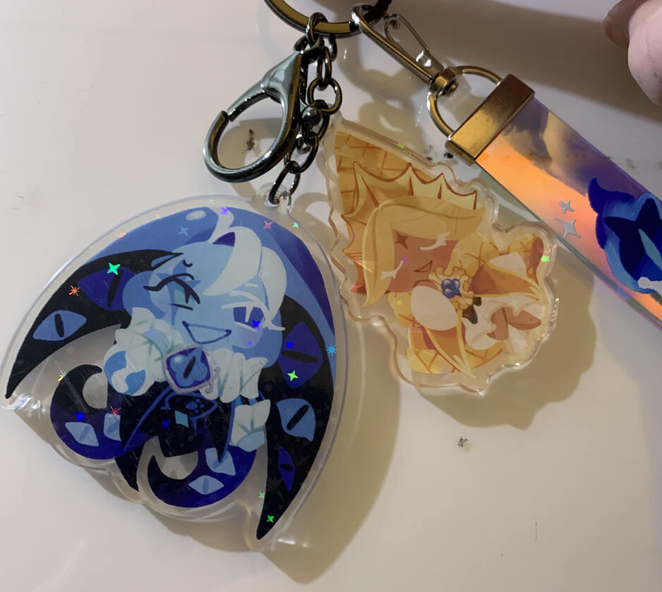 An acrylic keychain and PVC strap I was commissioned to design. The art is my own, but the original character designs are from Cookie Run.